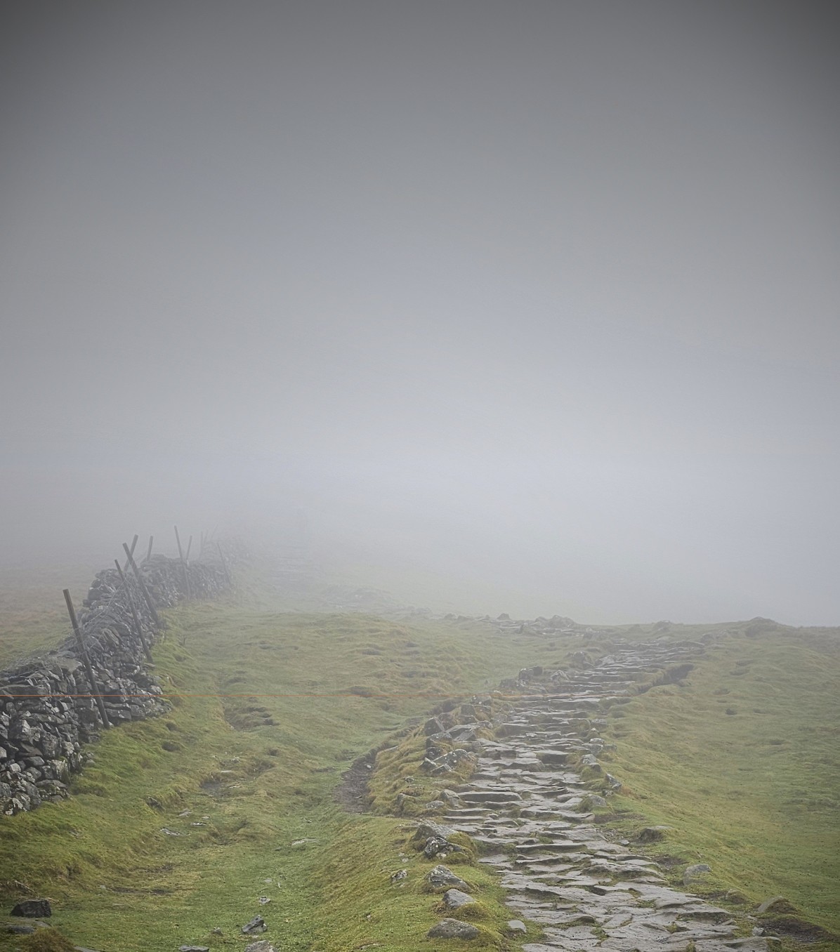 A foreboding rocky mountain ridge in mist, representing the lived reality of climbing the wrong mountain